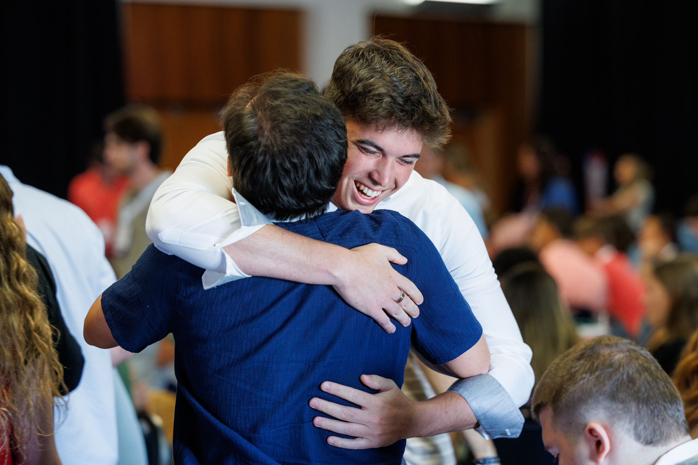 Two attendees greeting one another at a gathering